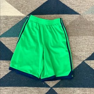 Green Adidas shorts with blue stripes.